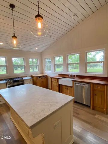 a kitchen with stainless steel appliances granite countertop wooden floors and white cabinets