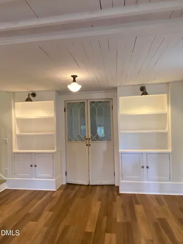 a view of empty room with wooden floor