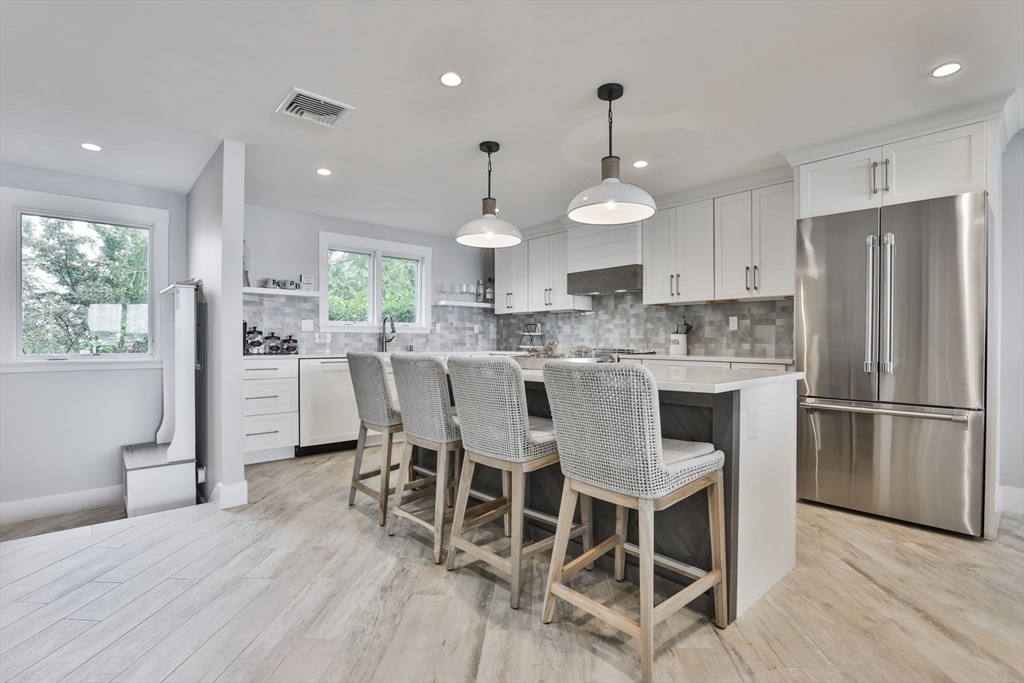 45 Raymond Street, Unit 7 Manchester, MA 01944 - Photo 2 of 40 a kitchen with stainless steel appliances a dining table chairs refrigerator sink and cabinets