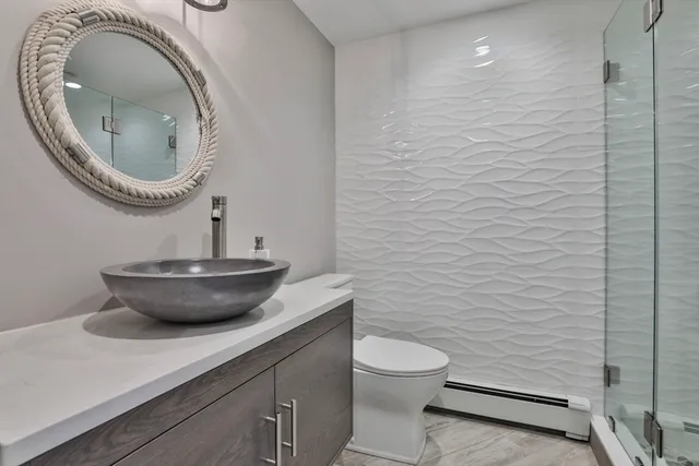 a bathroom with a toilet a sink and a mirror