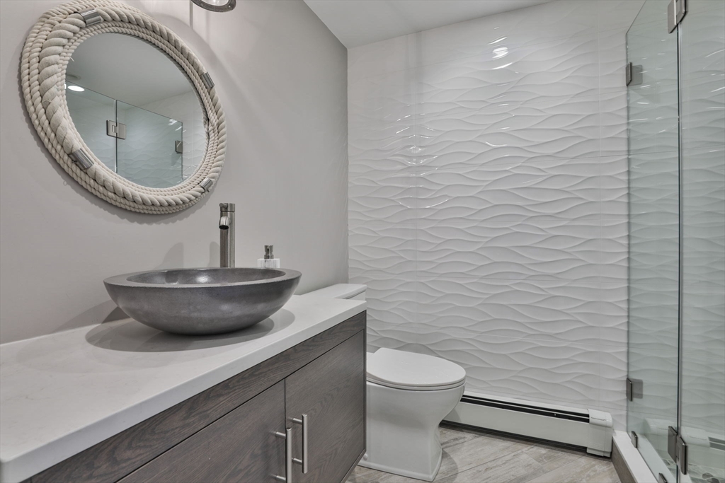 45 Raymond Street, Unit 7 Manchester, MA 01944 - Photo 26 of 40 a bathroom with a toilet a sink and a mirror