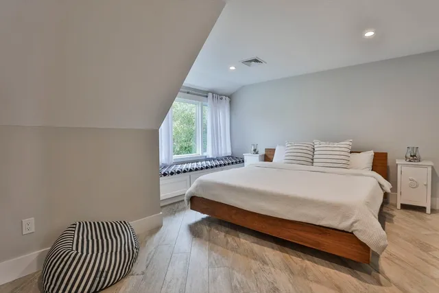 a bedroom with a bed and a large window