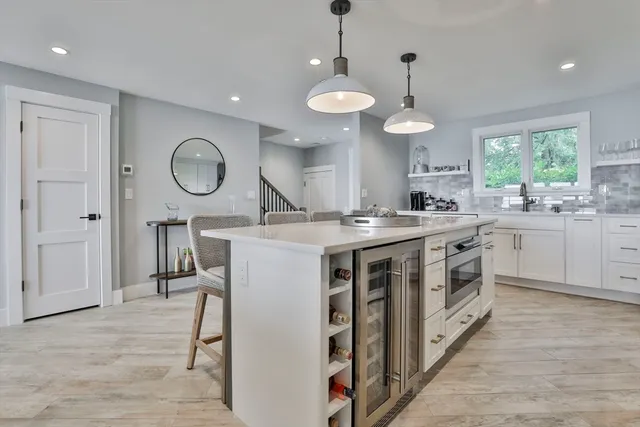 a kitchen with a stove oven a sink dishwasher and a clock on the wall with wooden floor