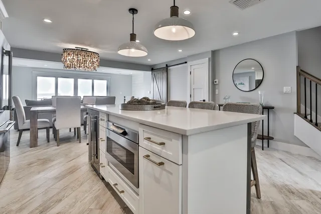 a kitchen with stainless steel appliances granite countertop a stove a sink a dining table and chairs