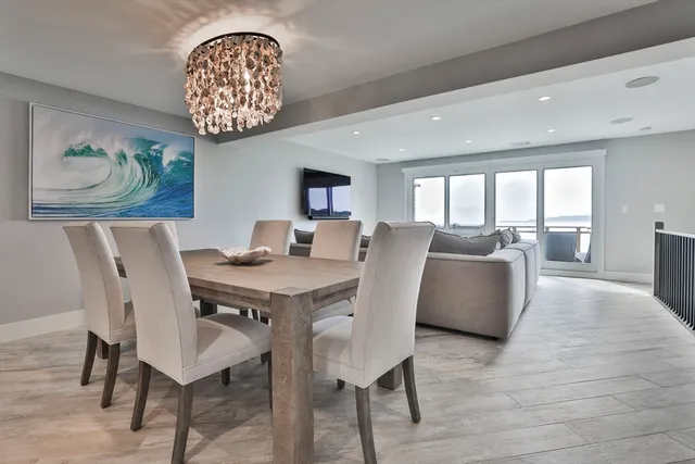 a view of a dining room with furniture a chandelier and wooden floor