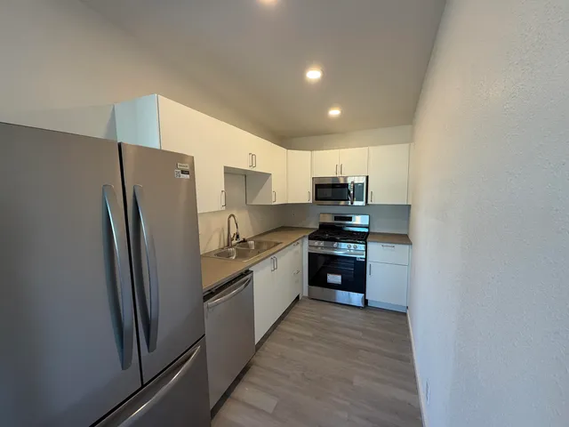 a large kitchen with a refrigerator and a sink