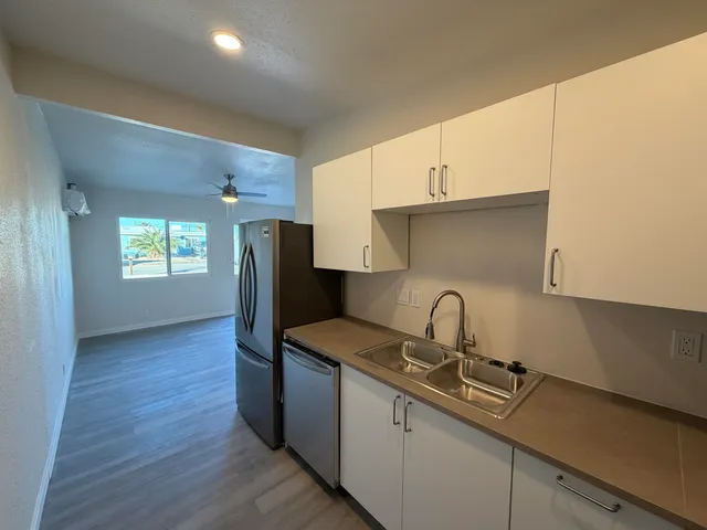 a kitchen with granite countertop a sink cabinets and stainless steel appliances