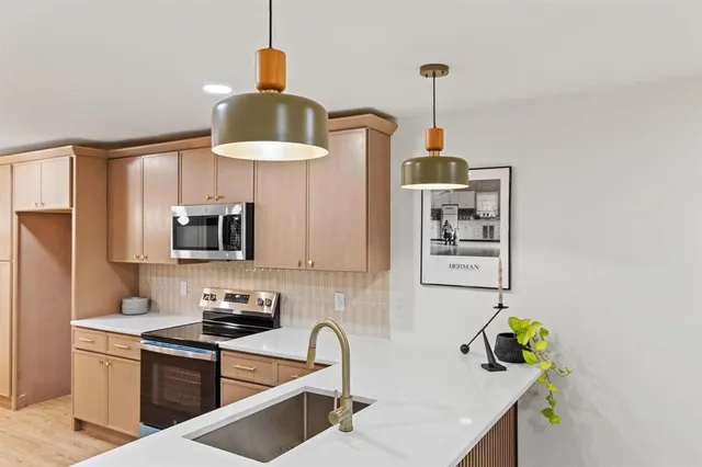 a kitchen with stainless steel appliances a microwave a stove and a wooden floor