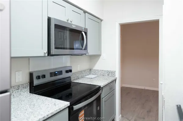 a kitchen with stainless steel appliances granite countertop a stove microwave and sink