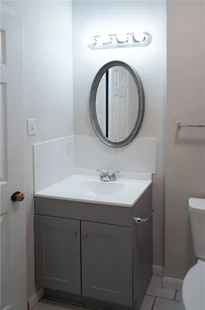 a bathroom with a sink a toilet and a mirror
