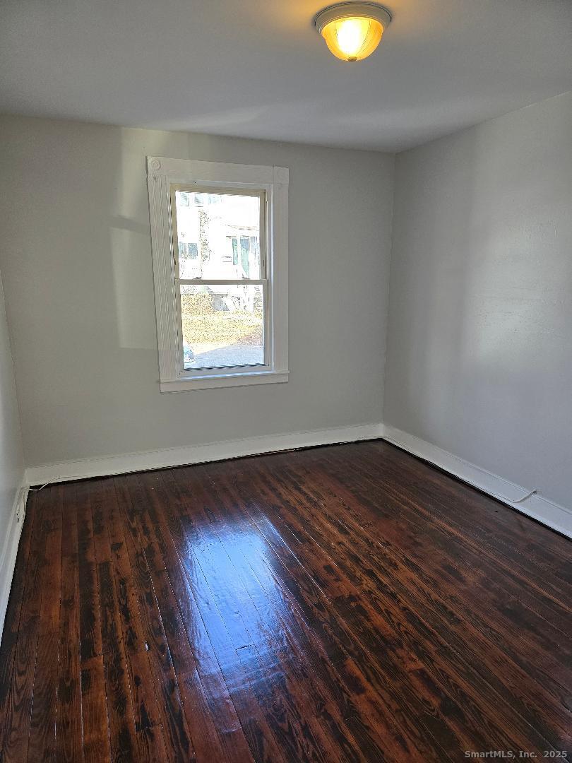 24 Cassidy Avenue Waterbury, CT 06704 - Photo 4 of 4 an empty room with wooden floor and windows