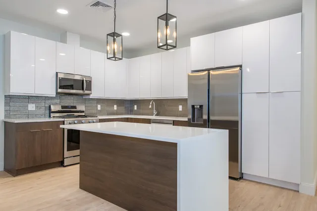 a kitchen with stainless steel appliances granite countertop a refrigerator and a stove top oven