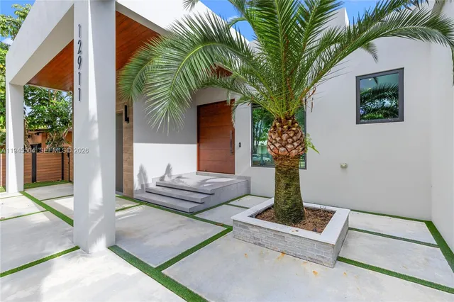 a patio with a table and chairs and potted plants