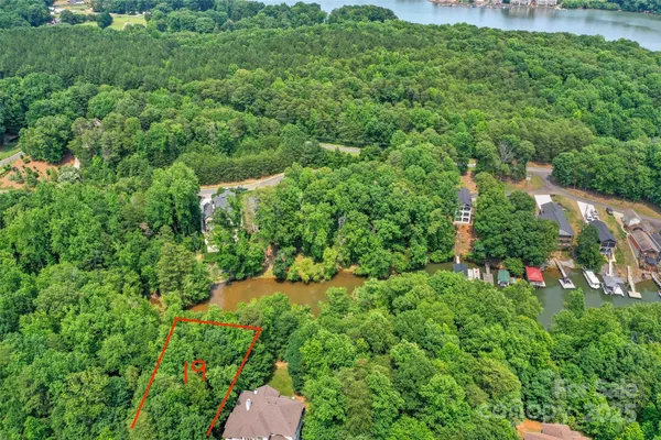 an aerial view of residential house with outdoor space and trees all around