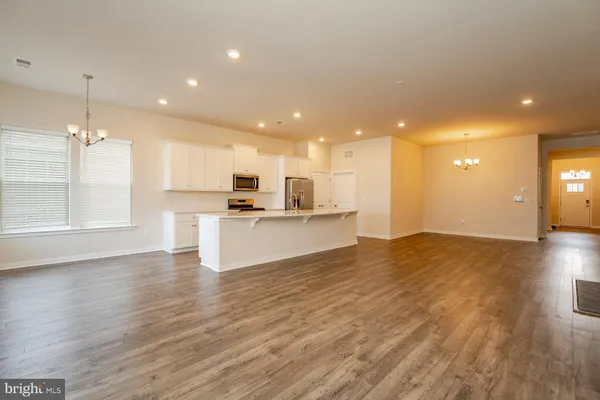 a view of kitchen with kitchen island wooden floor center island and stainless steel appliances