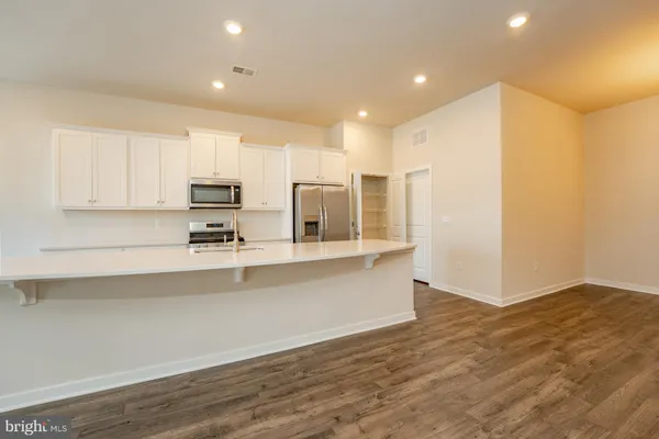 a view of kitchen with stainless steel appliances cabinets and wooden floor