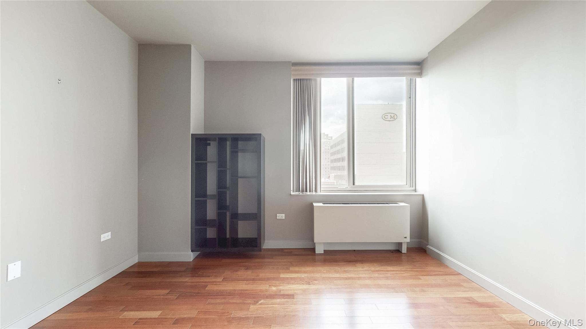 10724 71st Road, Unit 7E Queens, NY 11375 - Photo 14 of 21 Unfurnished room with radiator heating unit and light wood-style floors