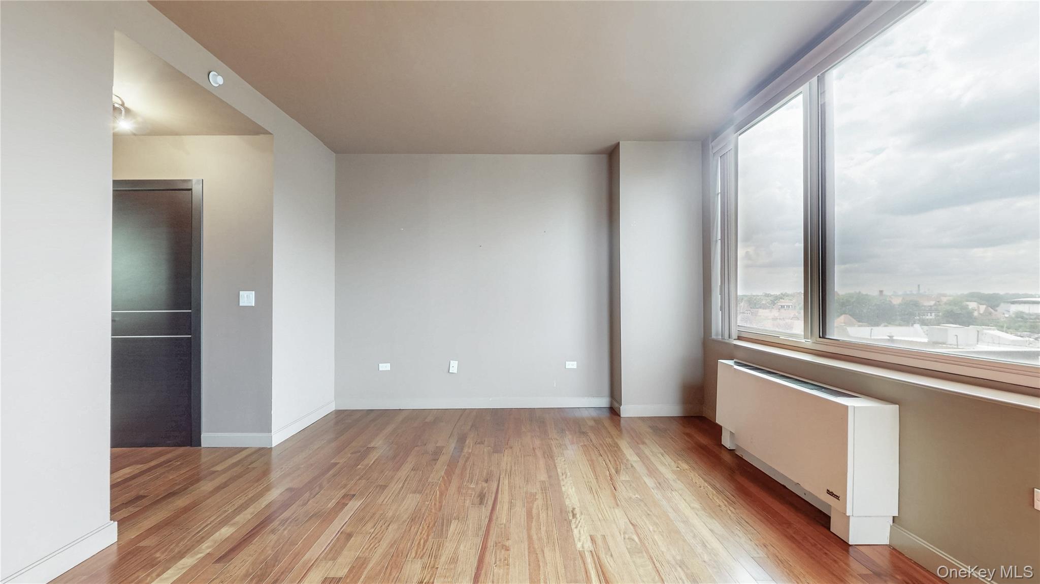 10724 71st Road, Unit 7E Queens, NY 11375 - Photo 18 of 21 Unfurnished room featuring radiator and light wood-type flooring