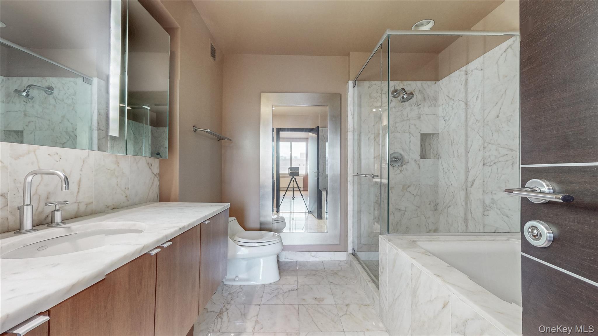 10724 71st Road, Unit 7E Queens, NY 11375 - Photo 19 of 21 Full bathroom featuring vanity, a marble finish shower, a garden tub, light marble finish floors, and decorative backsplash