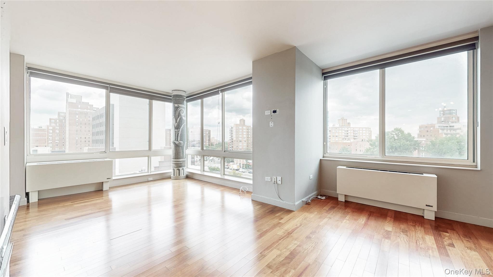 10724 71st Road, Unit 7E Queens, NY 11375 - Photo 10 of 21 Spare room with a view of skyline, radiator heating unit, and light wood finished floors