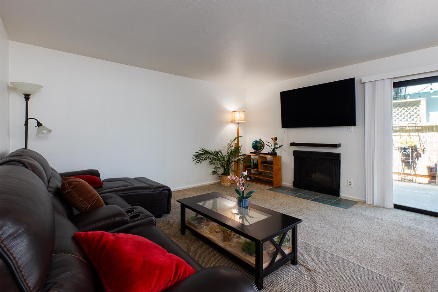 1925 46th Avenue, Unit 121 Capitola, CA 95010 - Photo 4 of 22 a living room with furniture a flat screen tv and a fireplace