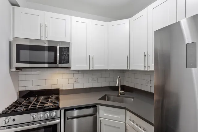 a kitchen with stainless steel appliances a stove a microwave and sink