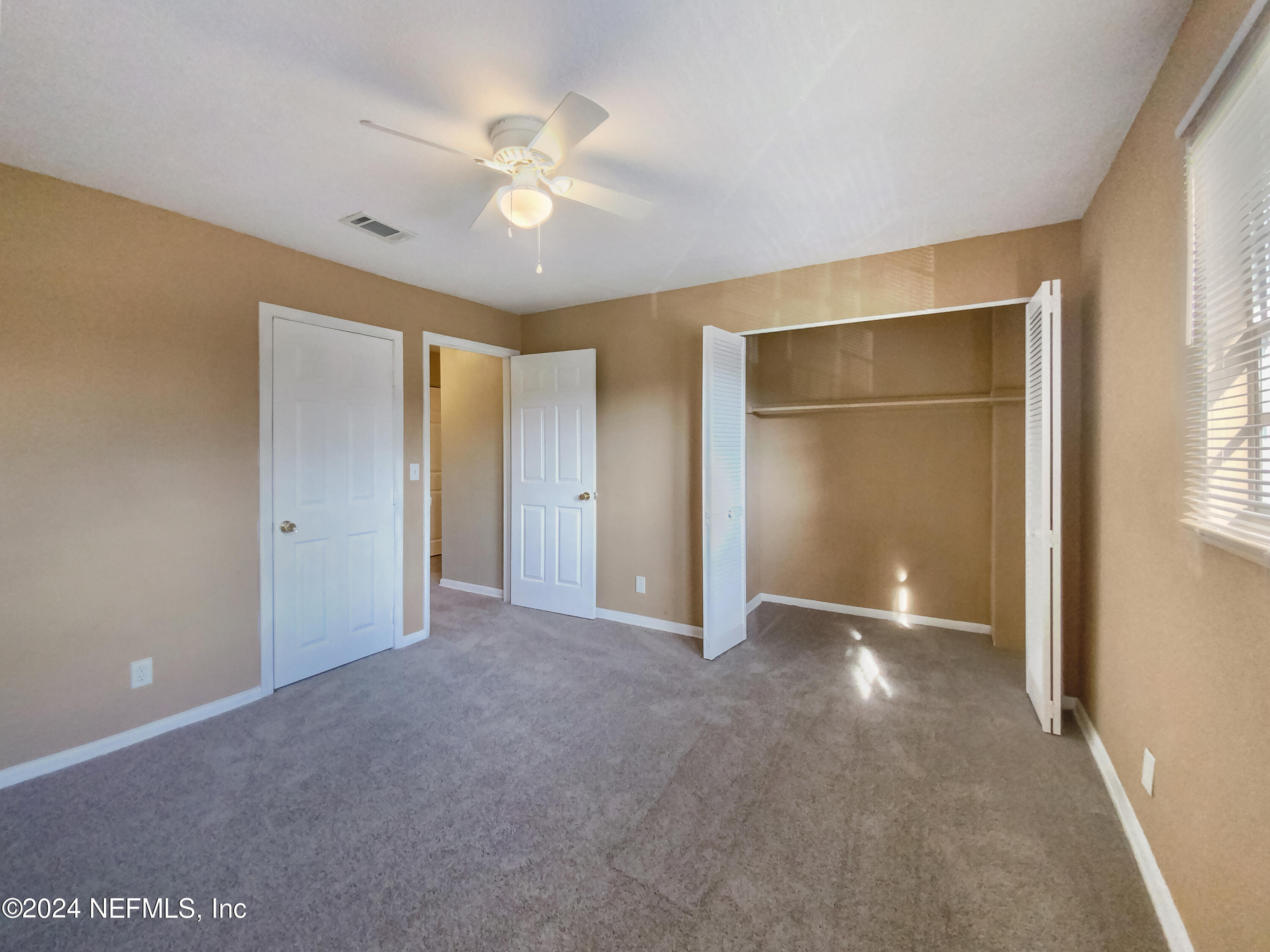 710 Cavalla Road Atlantic Beach, FL 32233 - Photo 16 of 17 a view of an empty room with window and chandelier fan
