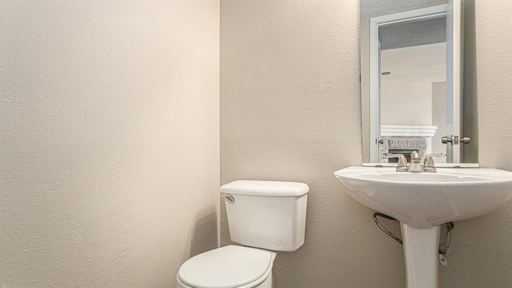 8732 Hunters Point Way Fort Worth, TX 76123 - Photo 13 of 24 a bathroom with a toilet sink and mirror