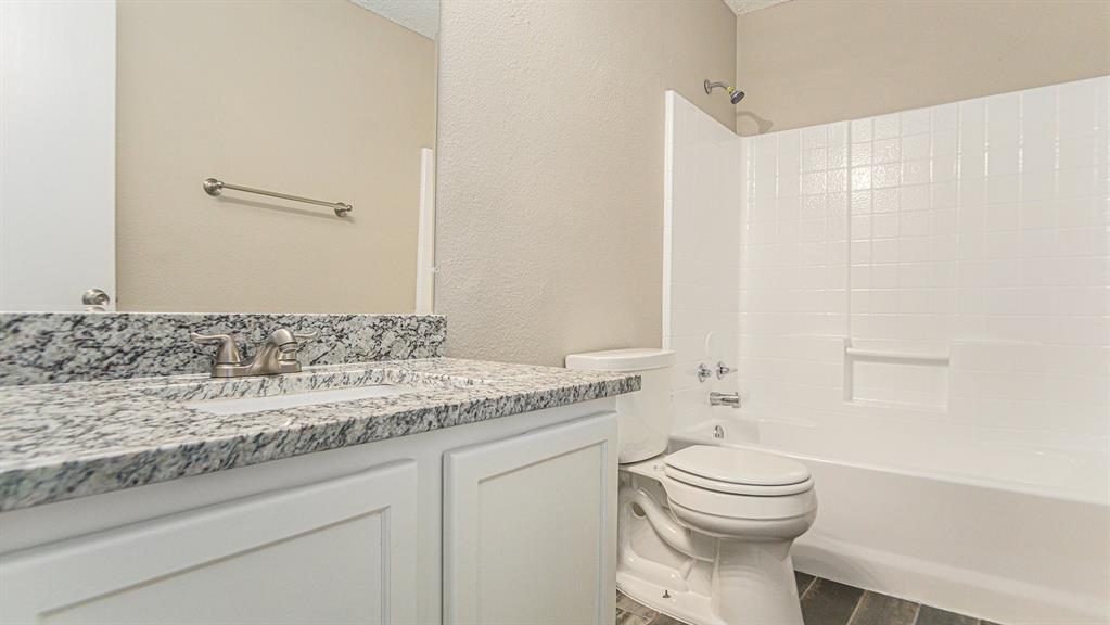 8732 Hunters Point Way Fort Worth, TX 76123 - Photo 20 of 24 a bathroom with a granite countertop sink a toilet and a bathtub