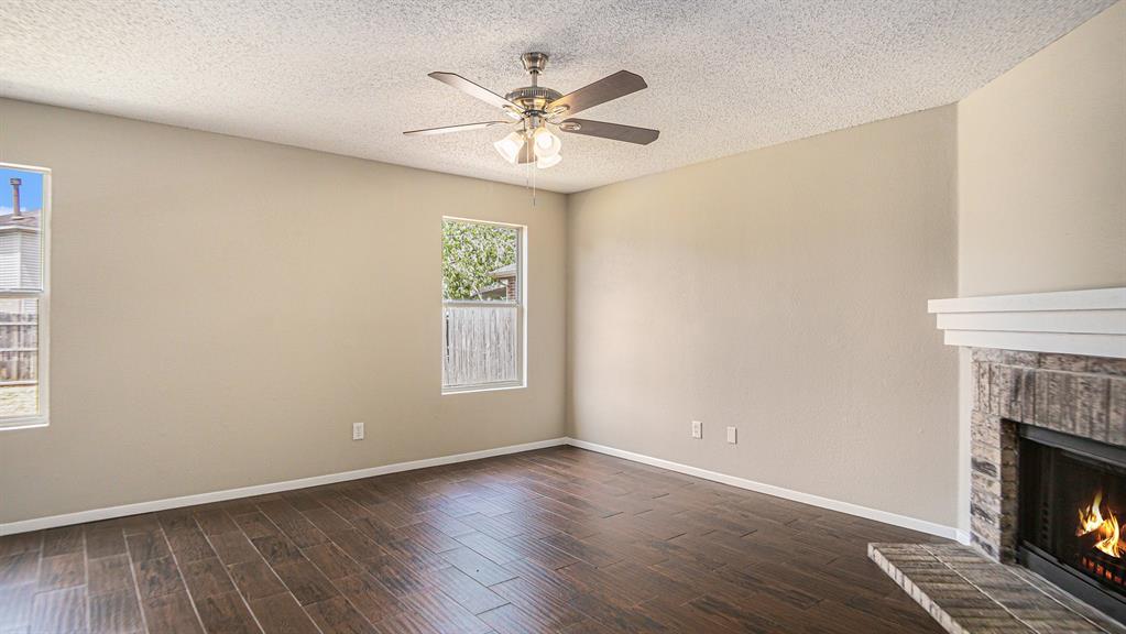 8732 Hunters Point Way Fort Worth, TX 76123 - Photo 4 of 24 an empty room with windows and a fireplace