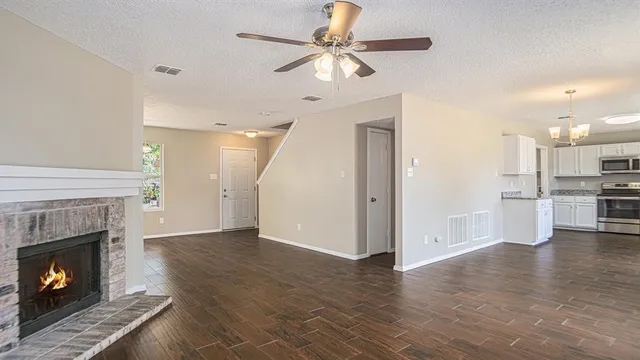 a view of a kitchen with a stove a fireplace and a chandelier fan