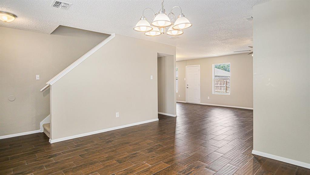 8732 Hunters Point Way Fort Worth, TX 76123 - Photo 8 of 24 wooden floor in an empty room with a window