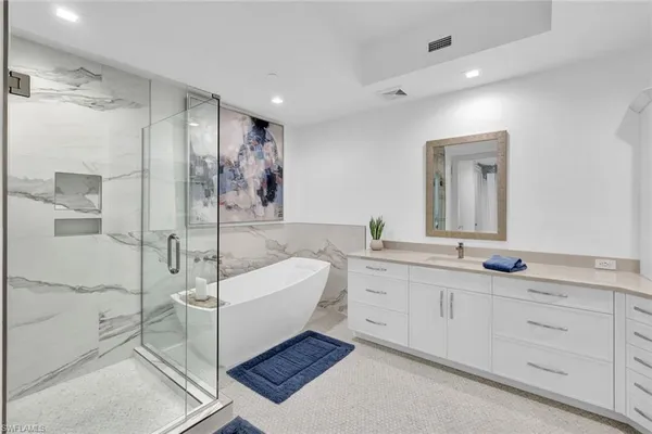 a spacious bathroom with a double vanity sink a mirror and a shower