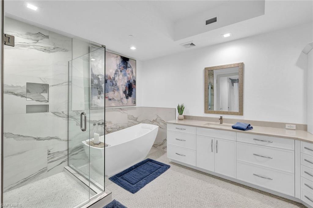 1030 3rd Avenue South, Unit 419 Naples, FL 34102 - Photo 11 of 29 a spacious bathroom with a double vanity sink a mirror and a shower