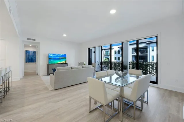 a dining room with furniture and large windows