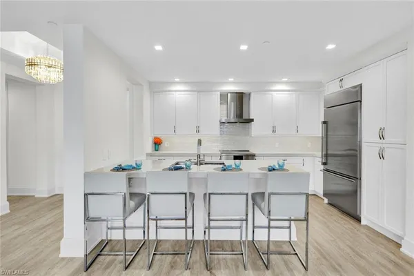 a kitchen with stainless steel appliances a table and chairs in it