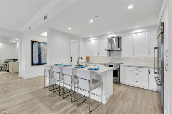 a kitchen with white cabinets and stainless steel appliances