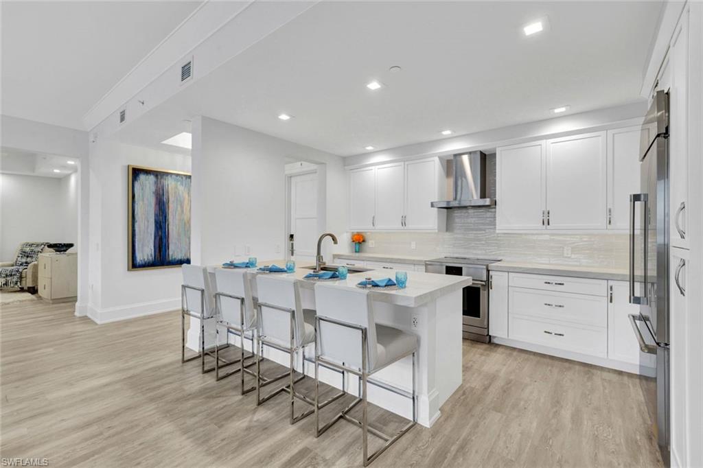 1030 3rd Avenue South, Unit 419 Naples, FL 34102 - Photo 6 of 29 a kitchen with white cabinets and stainless steel appliances