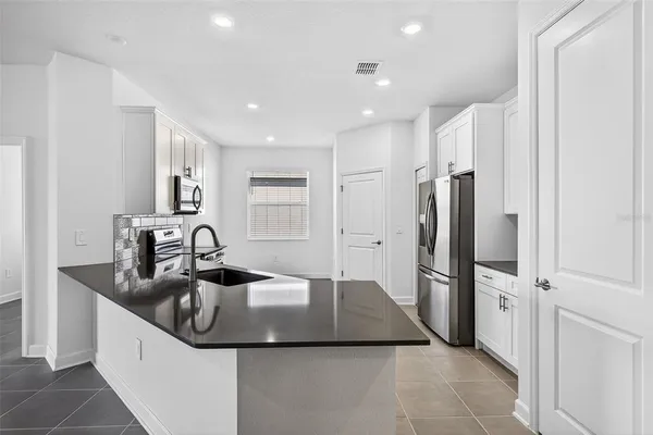 a kitchen with stainless steel appliances granite countertop a sink and a microwave