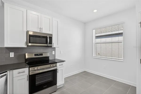 a kitchen with stainless steel appliances cabinets a sink and a microwave