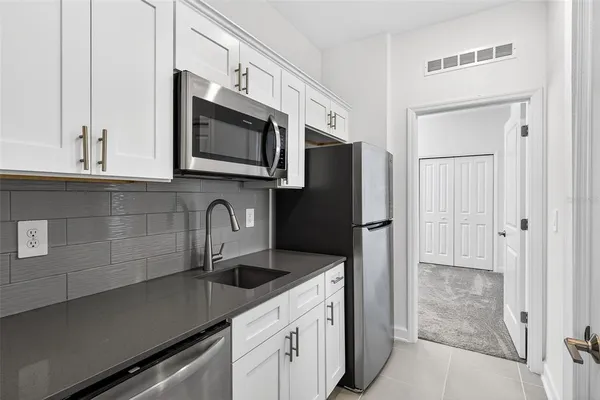 a view of a house with a big yard and large tree