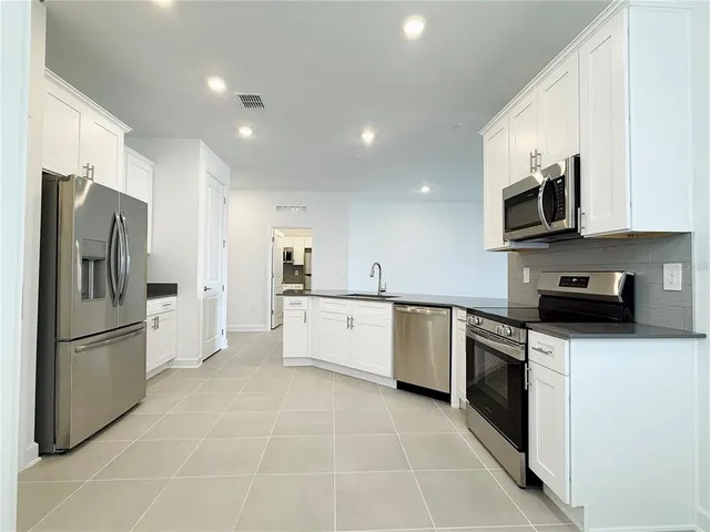 a kitchen with kitchen island a sink appliances and a counter top space