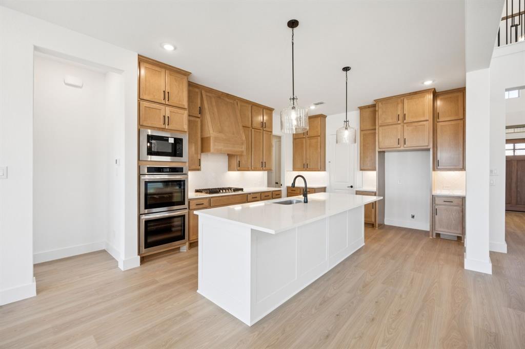 3412 Aldrich Road McKinney, TX 75071 - Photo 15 of 38 a large kitchen with kitchen island a sink stainless steel appliances and wooden floor