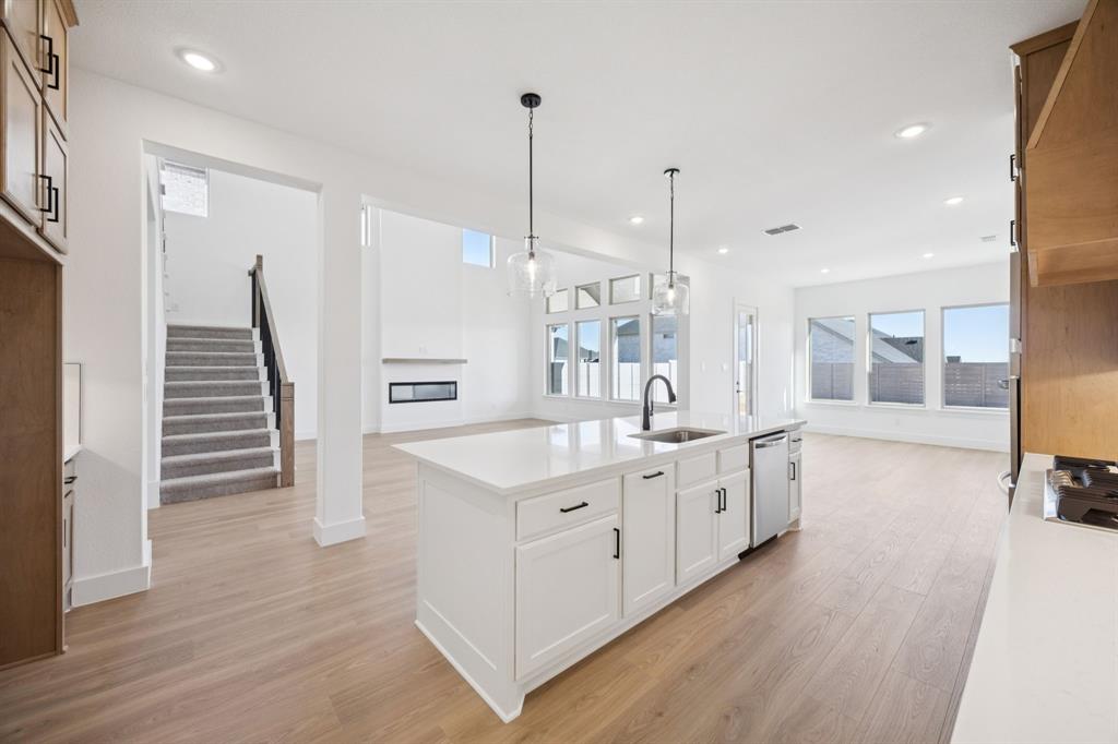 3412 Aldrich Road McKinney, TX 75071 - Photo 16 of 38 a large white kitchen with a lot of counter space and wooden floor