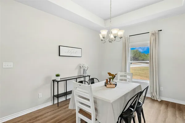 a view of a dining room with furniture wooden floor and chandelier
