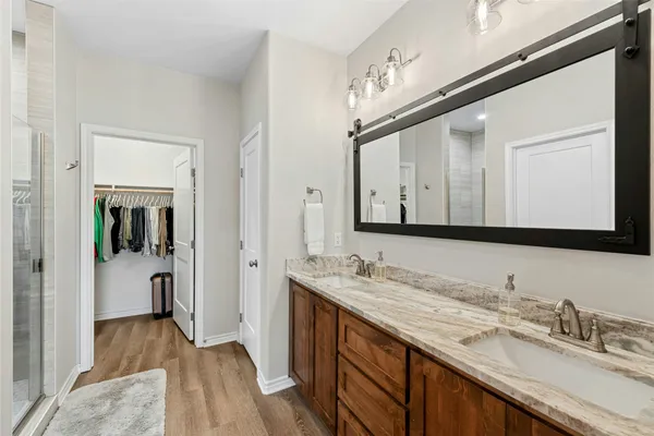 a en suite bathroom with a granite countertop sink and a mirror