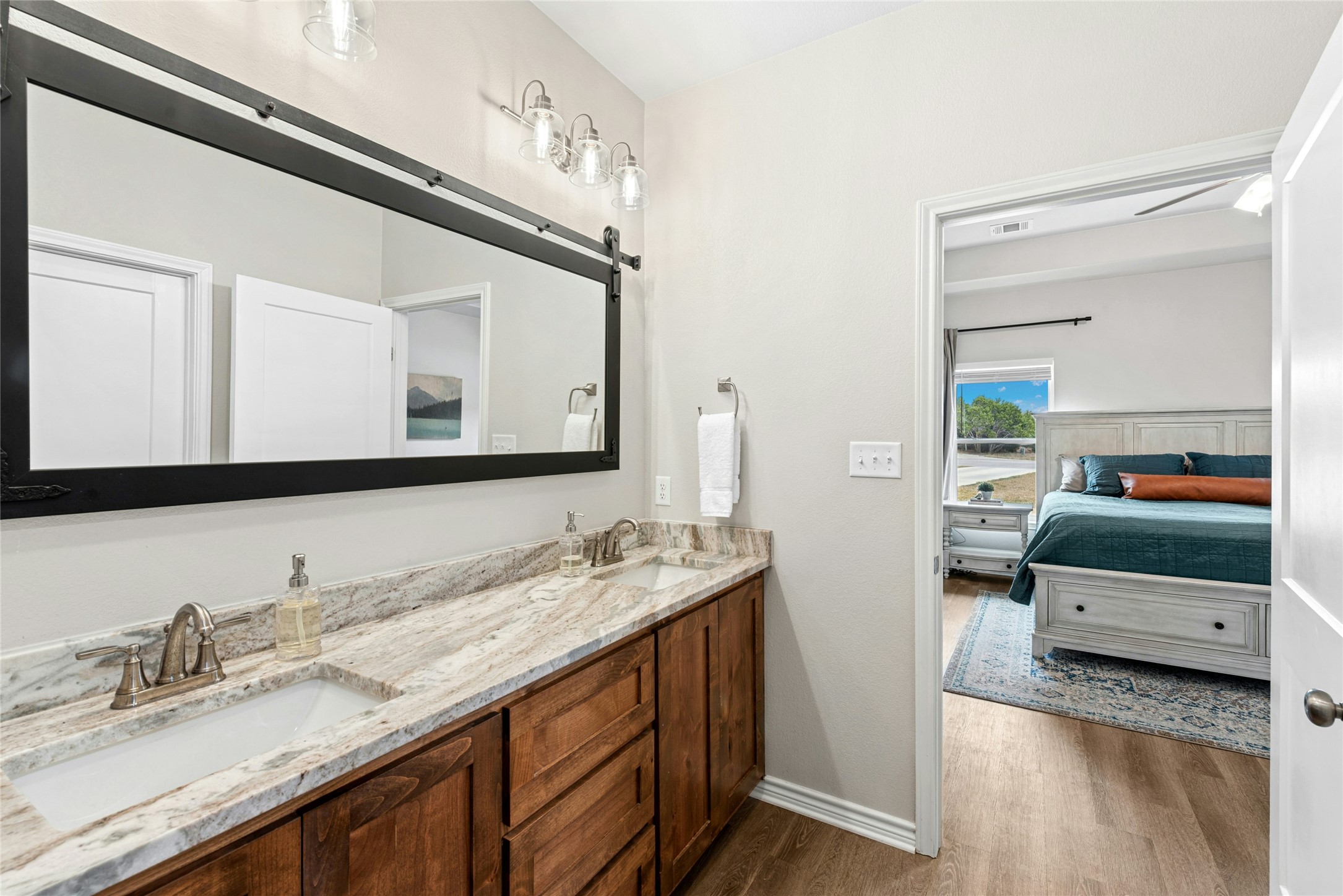 195 Rosebud Ranch Road Bertram, TX 78605 - Photo 24 of 40 a en suite bathroom with a double vanity sink and a mirror