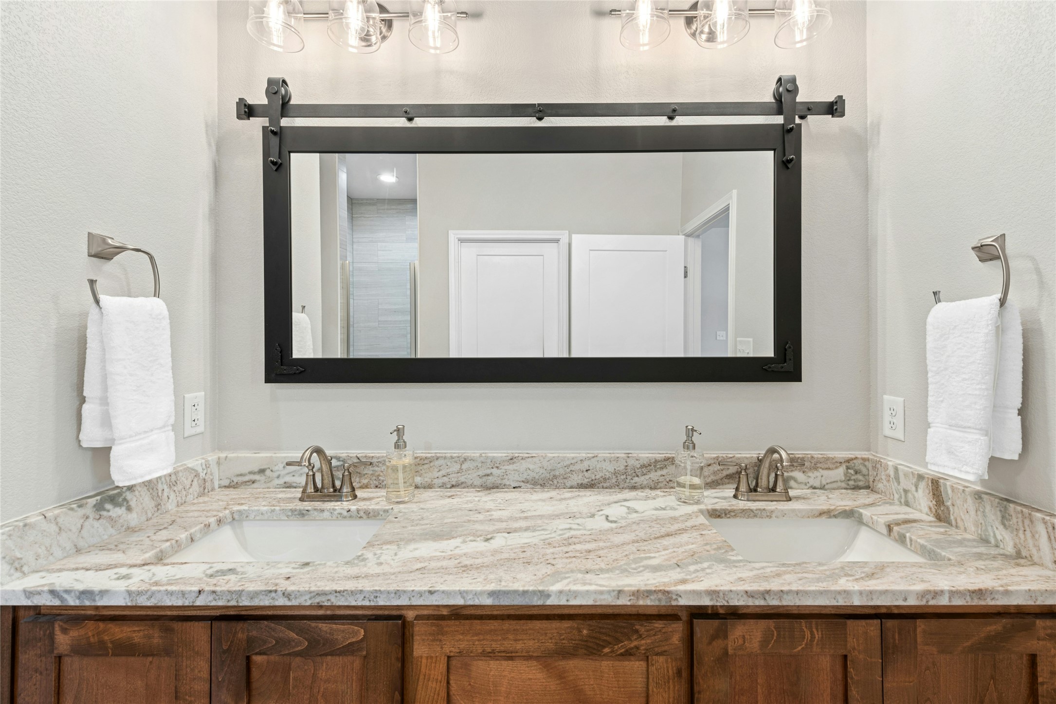 195 Rosebud Ranch Road Bertram, TX 78605 - Photo 25 of 40 a bathroom with a granite countertop sink and a mirror