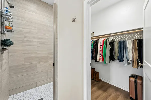 a view of walk in closet with clothes and shoes