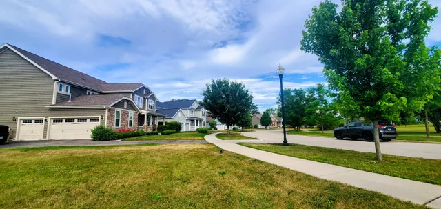 a view of a house with a big yard and large tree